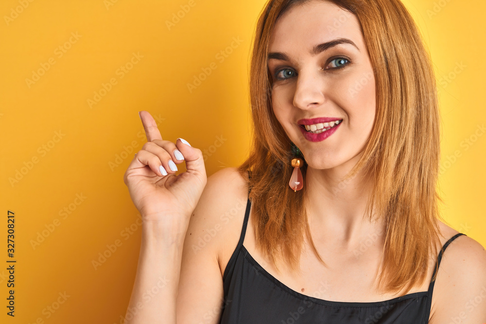Close up of caucasian elegant woman over isolated yellow background very happy pointing with hand and finger to the side Close up of caucasian elegant woman over isolated yellow background very happy pointing with hand and finger to the side