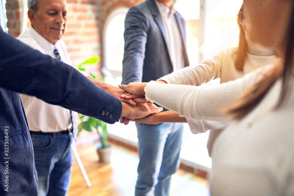 Group of business workers standing with hands together at the office
