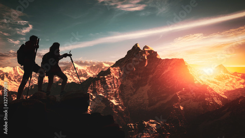 Young asian couple hikers climbing up on the peak of himalaya mountains. People helping each other hike up a mountain at sunrise. Giving a helping hand. Climbing ,Helps and team work concept