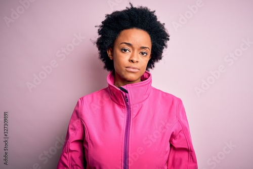 Young African American afro sportswoman with curly hair wearing sportswear doin sport Relaxed with serious expression on face. Simple and natural looking at the camera.