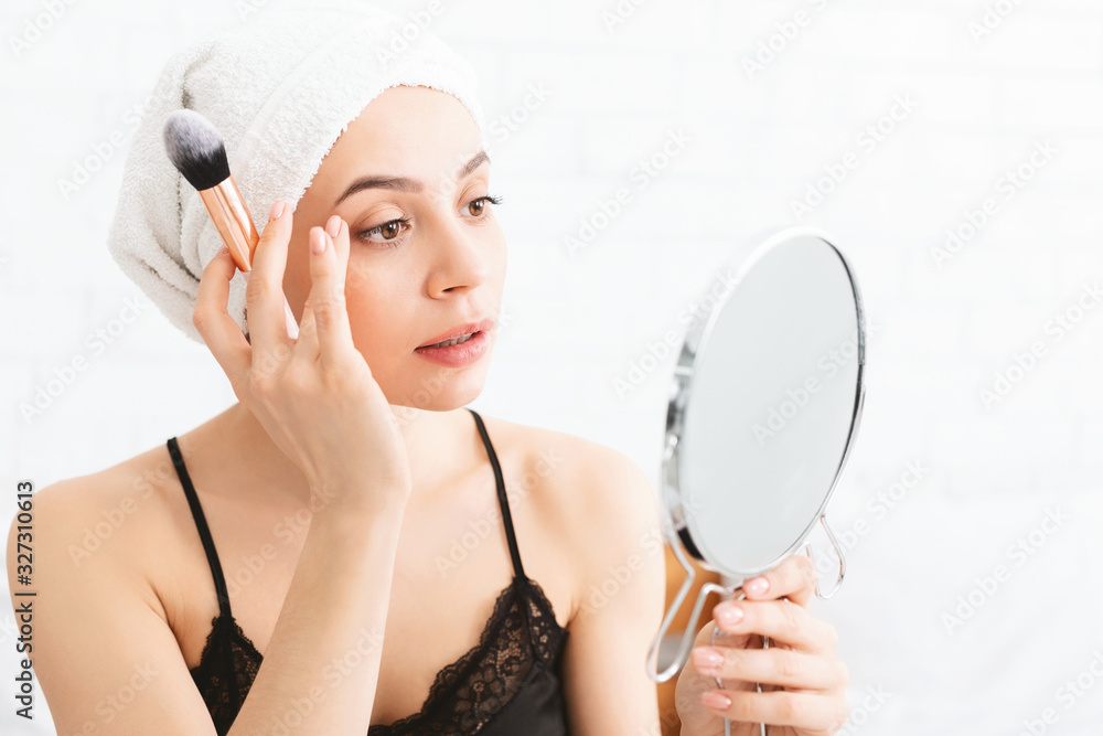 Pretty girl applying makeup, sitting after shower in bed Pretty girl applying makeup, sitting after shower in bed