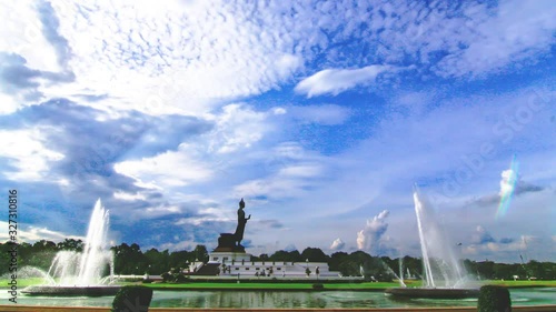 Time lapse clouds  ,Above the Buddha image, there is a fountain in the foreground.  ,At Phutthamonthon in Thailand photo