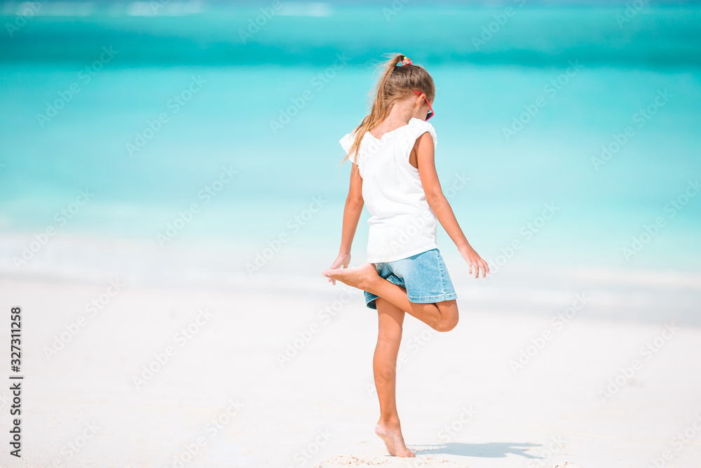 Adorable little girl have fun at tropical beach during vacation Adorable little girl have fun at tropical beach during vacation
