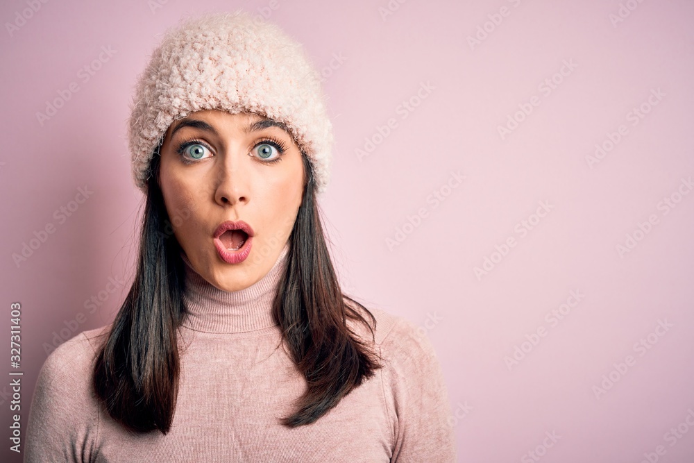 Young brunette woman with blue eyes wearing casual t-shirt and wool cap standing scared in shock with a surprise face, afraid and excited with fear expression Young brunette woman with blue eyes wearing casual t-shirt and wool cap standing scared in shock with a surprise face, afraid and excited with fear expression