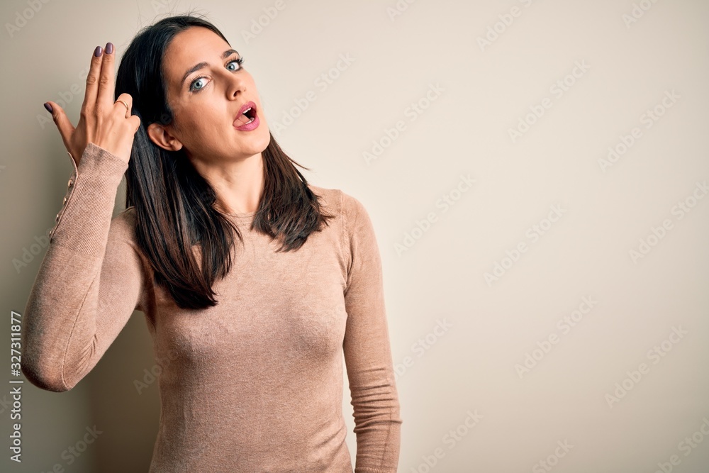 Fototapeta premium Young brunette woman with blue eyes wearing casual sweater over isolated white background Shooting and killing oneself pointing hand and fingers to head like gun, suicide gesture.