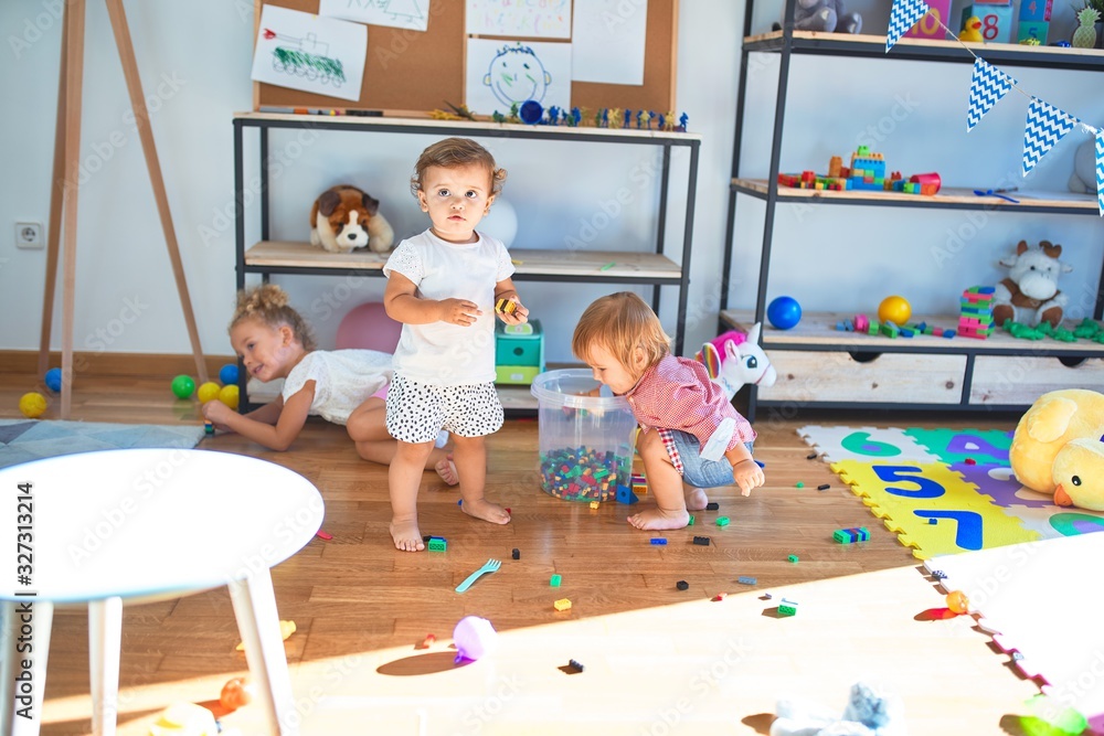 Adorable toddlers playing around lots of toys at kindergarten Adorable toddlers playing around lots of toys at kindergarten