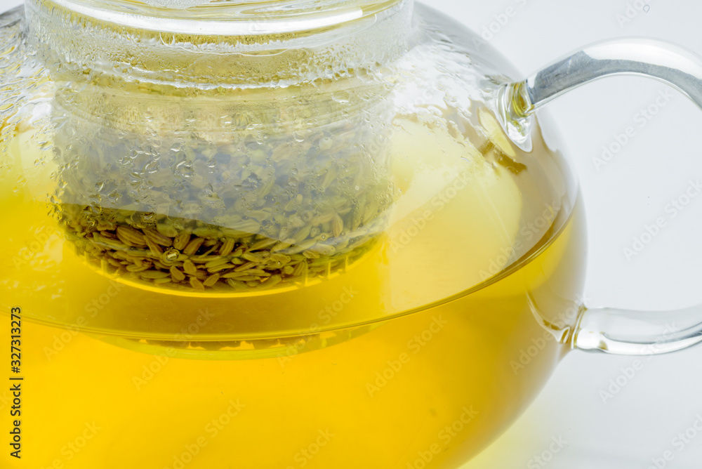 fennel seeds loose inside glass teapot brewed for healthy drink on white background fennel seeds loose inside glass teapot brewed for healthy drink on white background