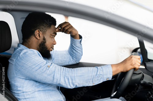 Depressed Man Sitting In Driver's Seat Of Too Expensive Car photo