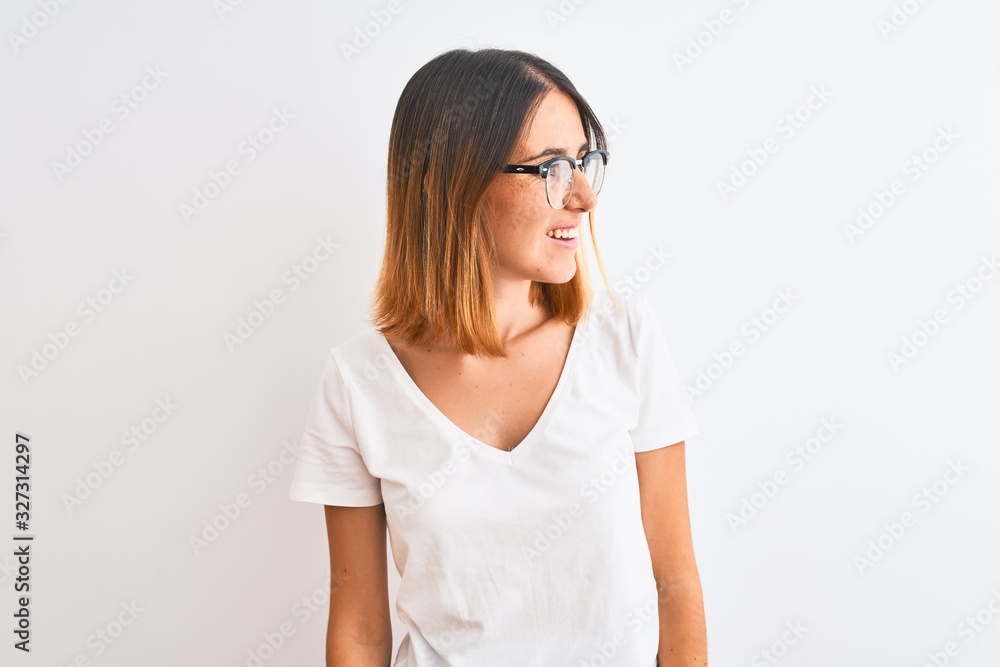 Beautiful redhead woman wearing glasses over isolated background looking away to side with smile on face, natural expression. Laughing confident. Beautiful redhead woman wearing glasses over isolated background looking away to side with smile on face, natural expression. Laughing confident.