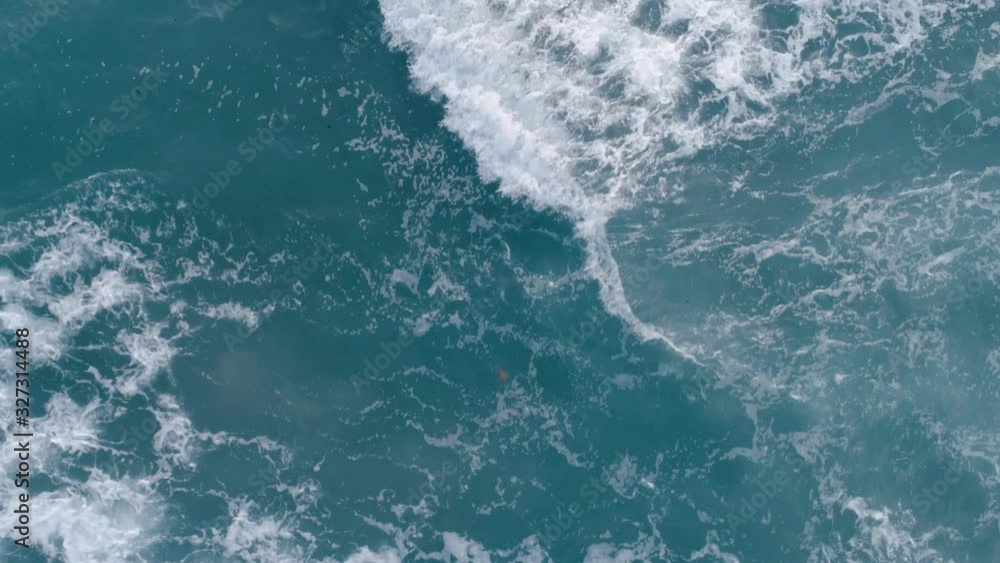 Top down aerial view of giant ocean waves crashing and foaming. Top down aerial view of giant ocean waves crashing and foaming.