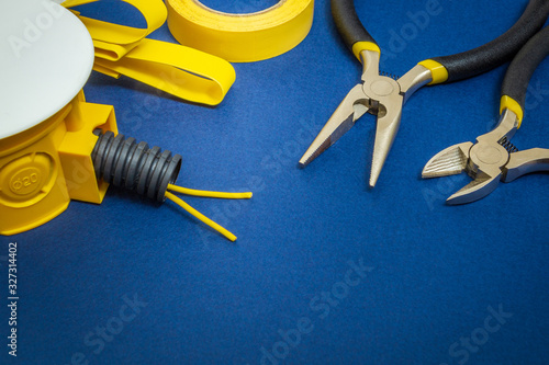 Kit yellow spare parts and tools for electrical prepared before repair or setting on blue background