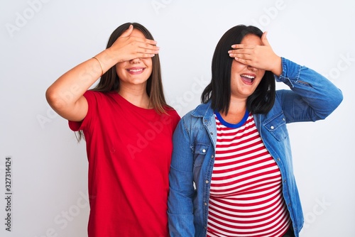 Young beautiful women wearing casual clothes standing over isolated white background smiling and laughing with hand on face covering eyes for surprise. Blind concept.