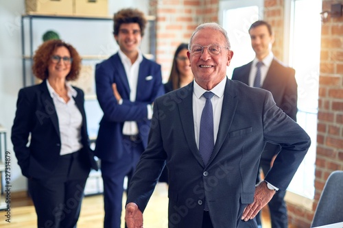 Group of business workers smiling happy and confident in a meeting. Standing with smile on face looking at camera at the office.