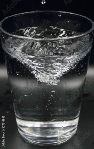 swirling spinning water in a glass with bubbles isolated on a black background