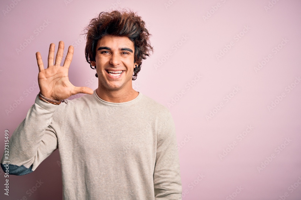 Young handsome man wearing casual t-shirt standing over isolated pink background showing and pointing up with fingers number five while smiling confident and happy. Young handsome man wearing casual t-shirt standing over isolated pink background showing and pointing up with fingers number five while smiling confident and happy.