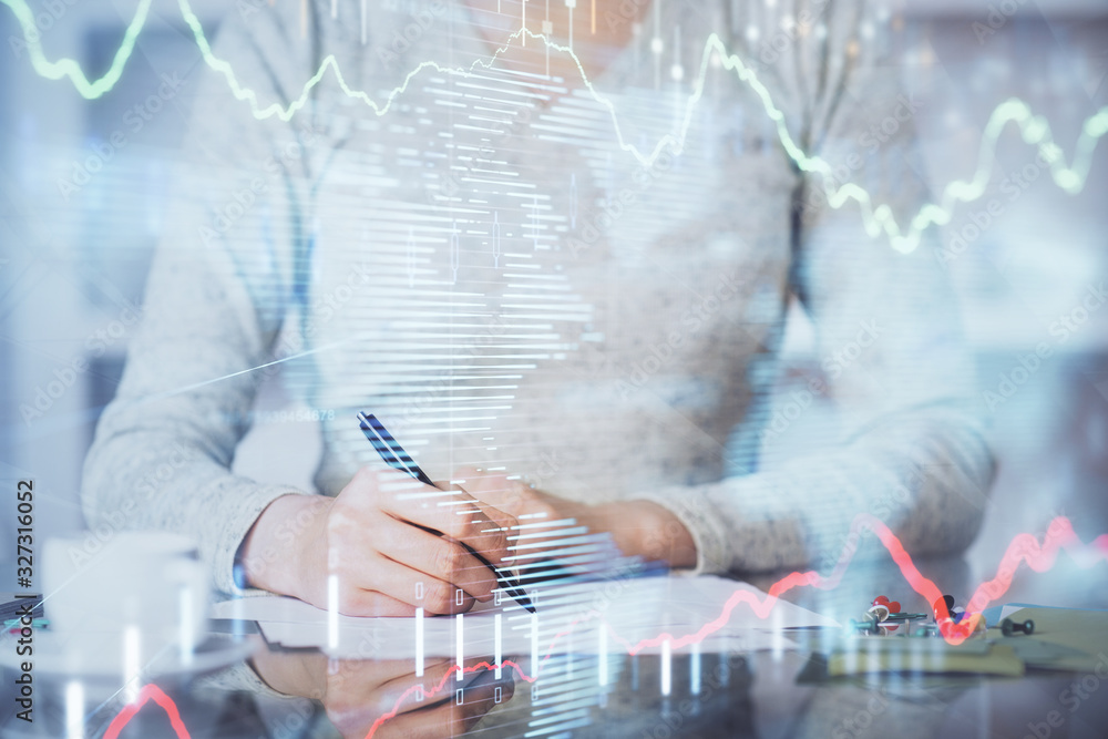 Hand taking notes in notepad. Forex chart holograms in front. Concept of research. Double exposure Hand taking notes in notepad. Forex chart holograms in front. Concept of research. Double exposure