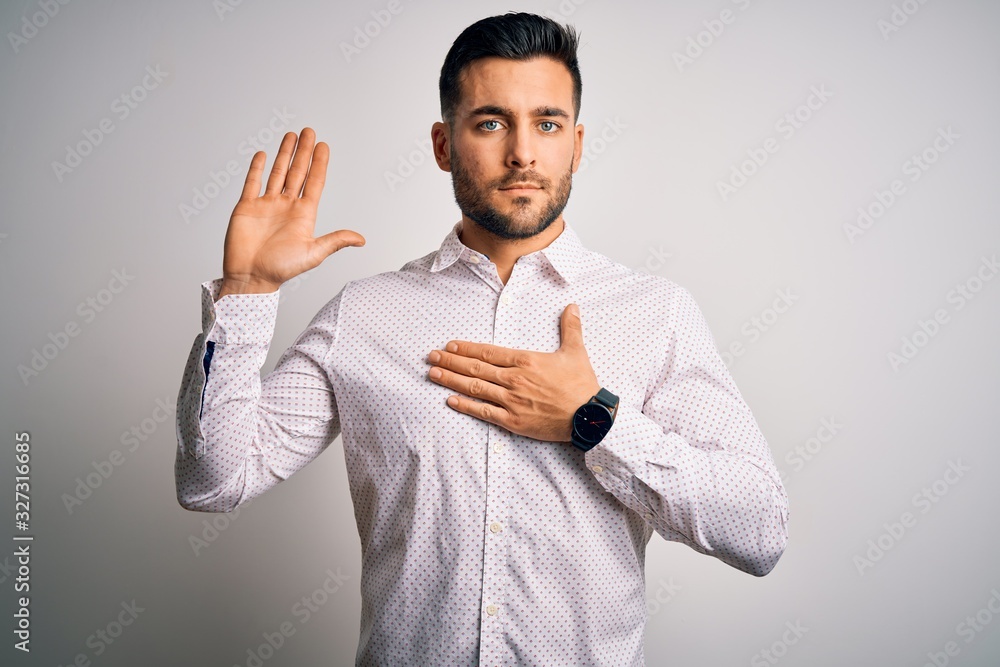 Young handsome man wearing elegant shirt standing over isolated white background Swearing with hand on chest and open palm, making a loyalty promise oath Young handsome man wearing elegant shirt standing over isolated white background Swearing with hand on chest and open palm, making a loyalty promise oath