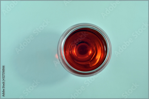  Glass of red wine on a light green background