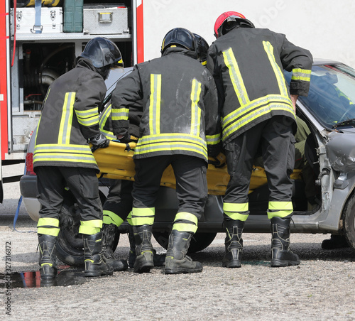 firefighters with the stretcher pull the injured out of the car