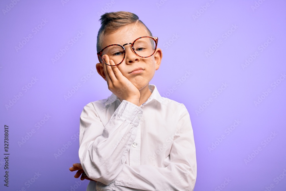 Young little caucasian kid with blue eyes wearing glasses and white shirt over purple background thinking looking tired and bored with depression problems with crossed arms.