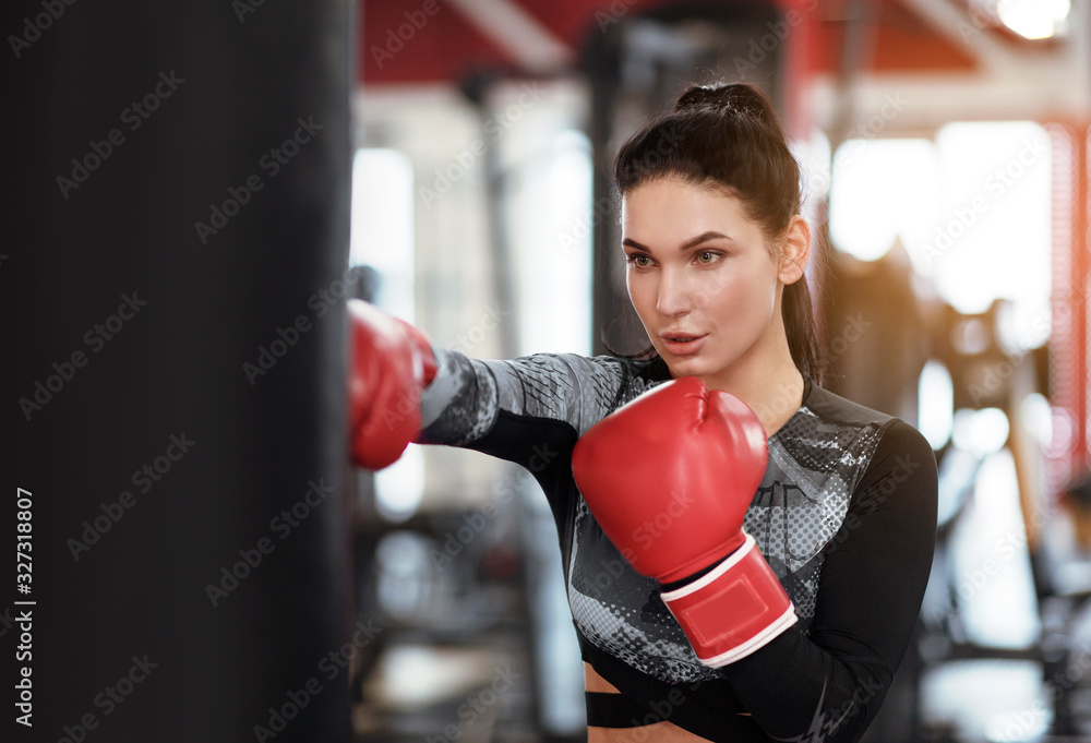Sports concept. Young female boxer working out in gym