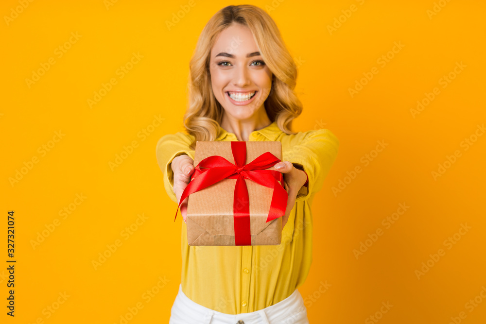 Pleasant gift. Woman stretching present box to camera Pleasant gift. Woman stretching present box to camera