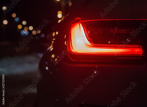 rear position lamp of a car glowing in the night. © Yuri Bizgaimer
