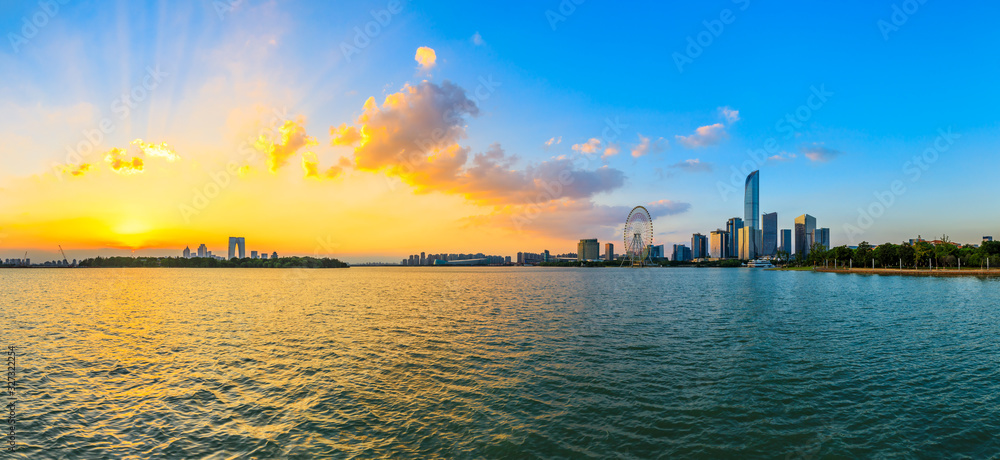 Beautiful city skyline and buildings with lake at sunset in Suzhou,panoramic view.