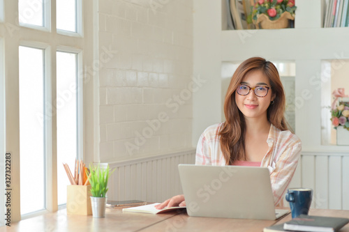 Young asian businesswoman with a laptop.She smiled happily in the comfortable office.