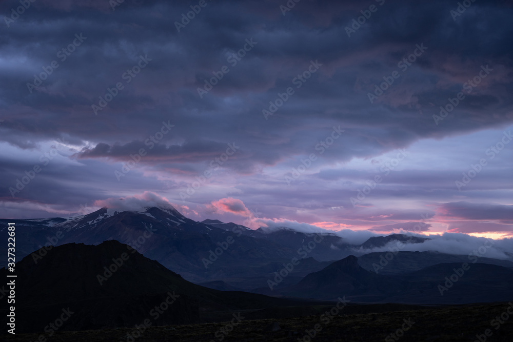 Mountain peak with snow and clouds during dramatic and colorful sunset on the laugavegur Hiking trail close to Thorsmork