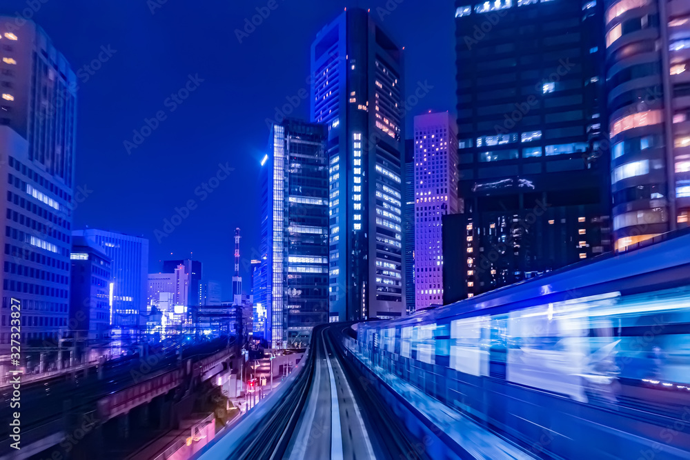 Japan. The train goes through Tokyo in the evening. The train rushes along the tracks along the skyscrapers. Railway traffic in the business part of Tokyo. Evening life of the Japanese capital.