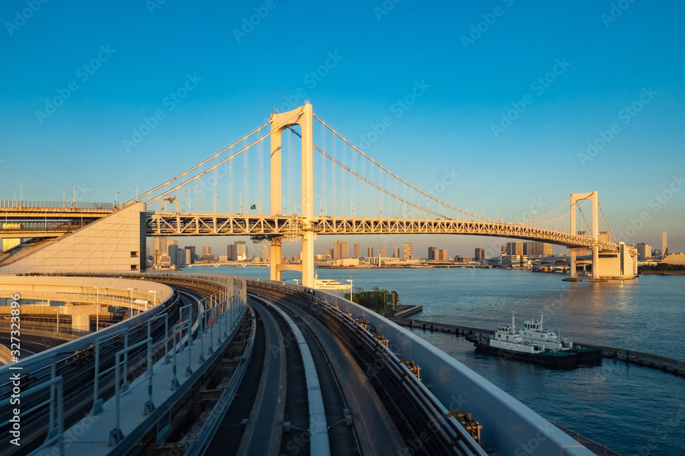 Obraz premium Japan. Railway tracks and rainbow bridge in Tokyo. Transport system of the capital of Japan. Rainbow bridge on the background of Odaiba island. Artificial Islands in Tokyo. Guide to Japan.