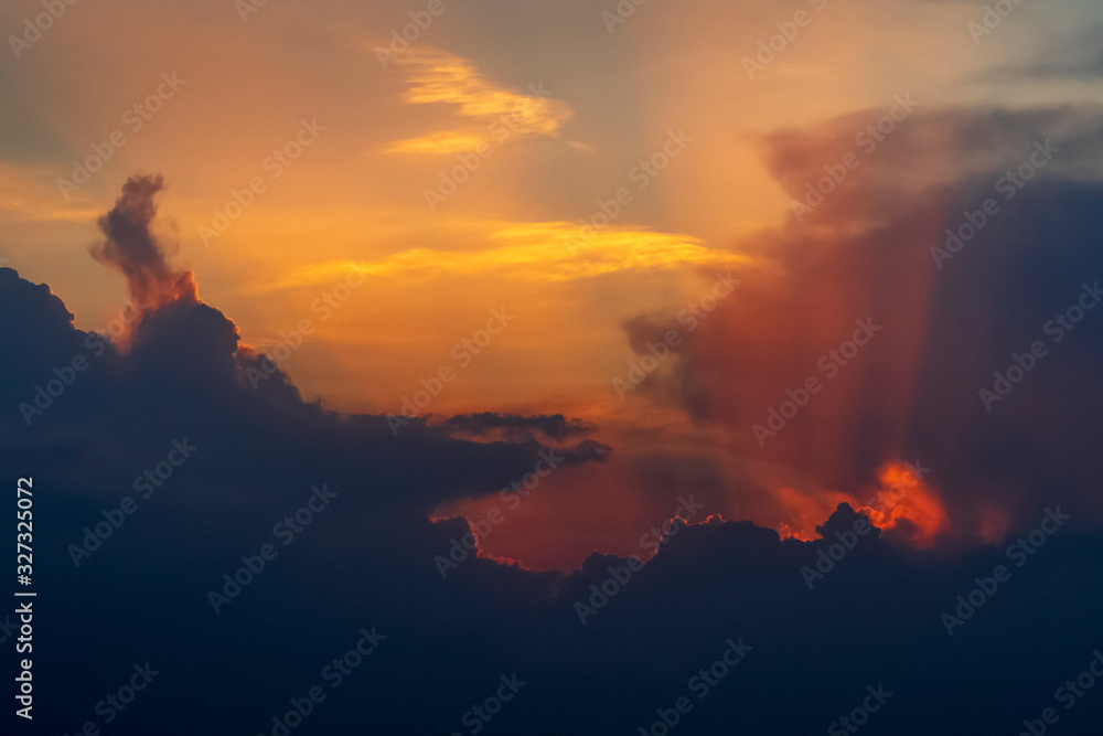 Dramatic sunset sky with sun rays and clouds. Natural background with copy space
