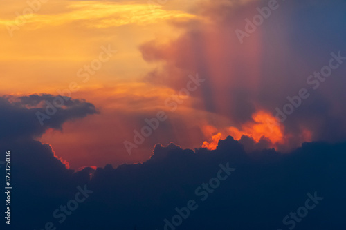 Dramatic sunset sky with sun rays and clouds. Natural background with copy space