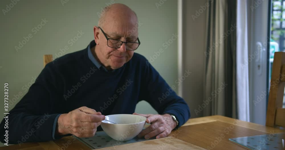Senior man eating breakfast by the window Senior man eating breakfast by the window