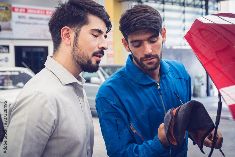 Mechanic checking car with the owner. Auto services concepts Mechanic checking car with the owner. Auto services concepts