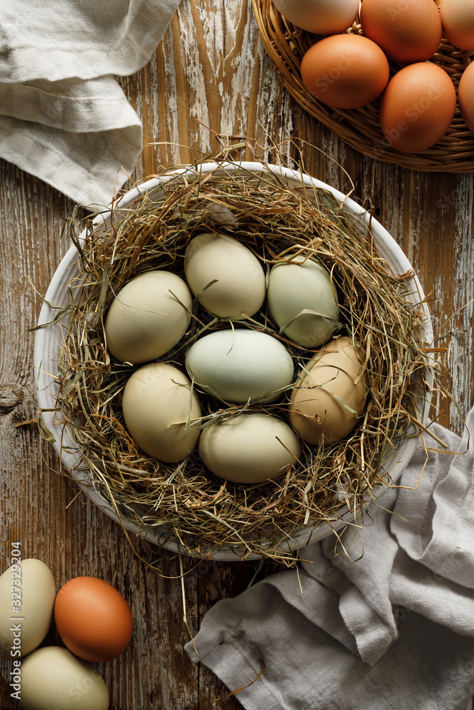 Fresh eggs from an organic farm on hay on a wooden rustic table top view Fresh eggs from an organic farm on hay on a wooden rustic table top view
