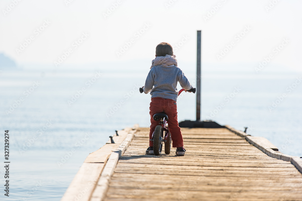 Enfant seul en vélo sur un ponton