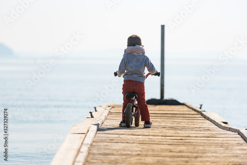 Enfant seul en vélo sur un ponton