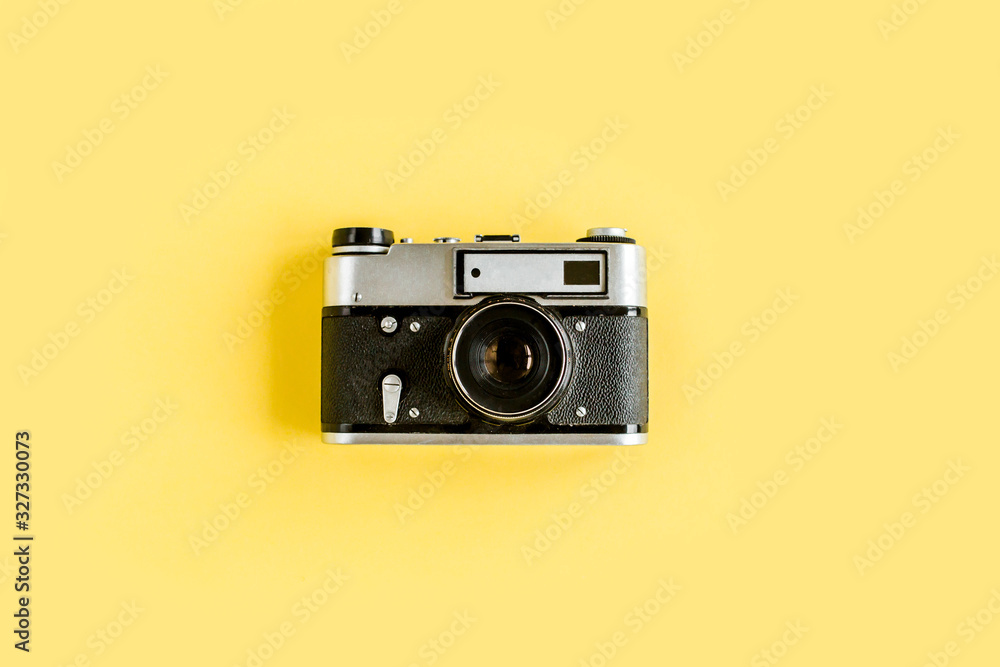 Retro camera isolated on yellow background.  Flat lay, top view.