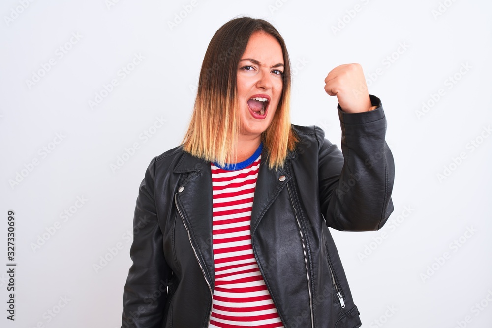 Young beautiful woman wearing striped shirt and jacket over isolated white background angry and mad raising fist frustrated and furious while shouting with anger. Rage and aggressive concept. Young beautiful woman wearing striped shirt and jacket over isolated white background angry and mad raising fist frustrated and furious while shouting with anger. Rage and aggressive concept.
