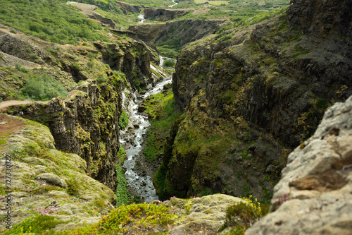 Botsna river canyon. Amazing green landscape of Icelandic Canyon. Fantastic misty weather, seagulls soaring over cliffs