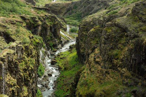 Botsna river canyon. Amazing green landscape of Icelandic Canyon. Fantastic misty weather, seagulls soaring over cliffs