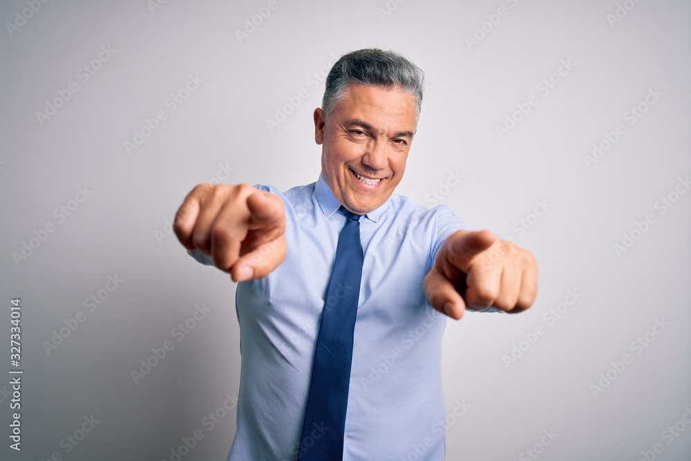 Middle age handsome grey-haired business man wearing elegant shirt and tie pointing to you and the camera with fingers, smiling positive and cheerful