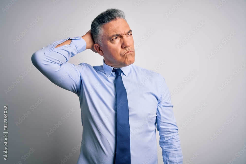 Middle age handsome grey-haired business man wearing elegant shirt and tie confuse and wondering about question. Uncertain with doubt, thinking with hand on head. Pensive concept. Middle age handsome grey-haired business man wearing elegant shirt and tie confuse and wondering about question. Uncertain with doubt, thinking with hand on head. Pensive concept.