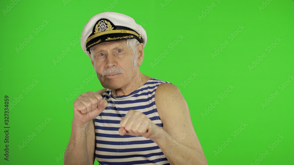 Elderly sailor man is angry and shows fists. Sailorman on chroma key background Elderly sailor man is angry and shows fists. Sailorman on chroma key background