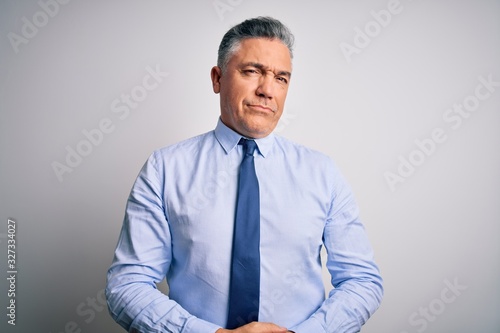Middle age handsome grey-haired business man wearing elegant shirt and tie with hands together and crossed fingers smiling relaxed and cheerful. Success and optimistic