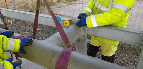 Fotografie riggers move the pipe with two chain blocks and attach the flange with bolts