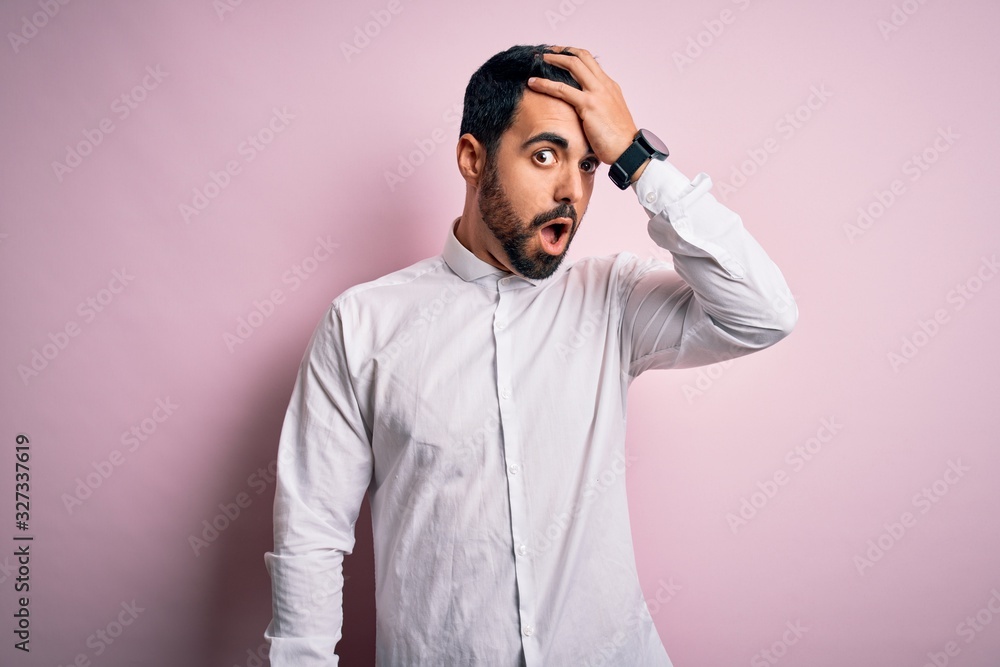 Young handsome man with beard wearing casual shirt standing over pink background surprised with hand on head for mistake, remember error. Forgot, bad memory concept. Young handsome man with beard wearing casual shirt standing over pink background surprised with hand on head for mistake, remember error. Forgot, bad memory concept.
