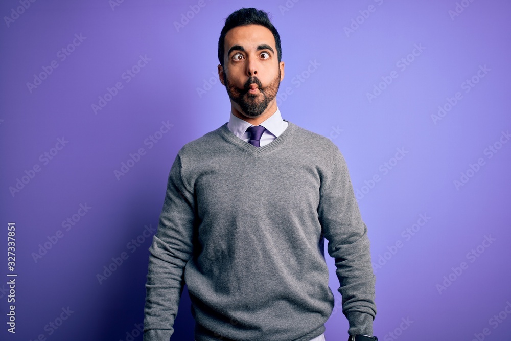 Handsome businessman with beard wearing casual tie standing over purple background making fish face with lips, crazy and comical gesture. Funny expression. Handsome businessman with beard wearing casual tie standing over purple background making fish face with lips, crazy and comical gesture. Funny expression.